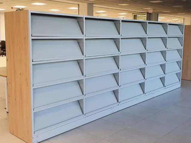 Zemi bibliotēku plaukti gaišā interjerā